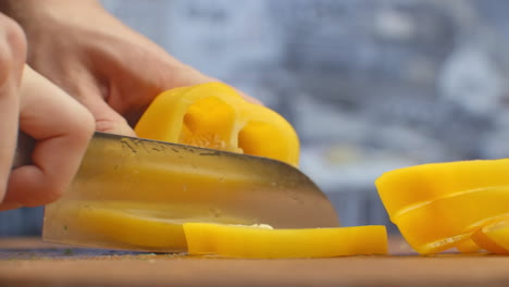 Close-up-of-cut-yellow-peppers-on-a-board-in-the-kitchen-on-a-wooden-board.